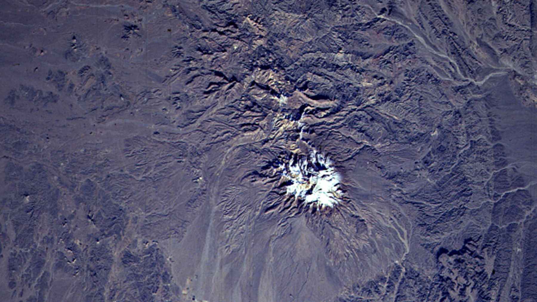 Taftan volcano in Iran showing summit area with signs of geothermal activity and gas emissions