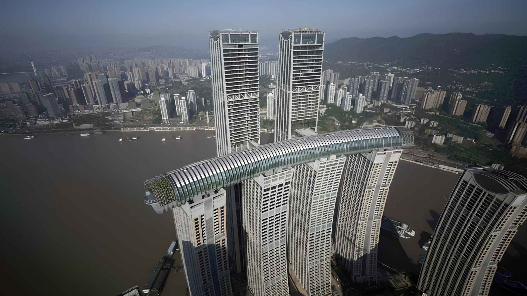 China built a 984-foot “horizontal skyscraper” linking four towers 820 feet up, and the about 13,200-ton structure turns architecture into a balance test 1 Aerial view of The Crystal at Raffles City Chongqing, a horizontal skyscraper connecting multiple towers high above the city.