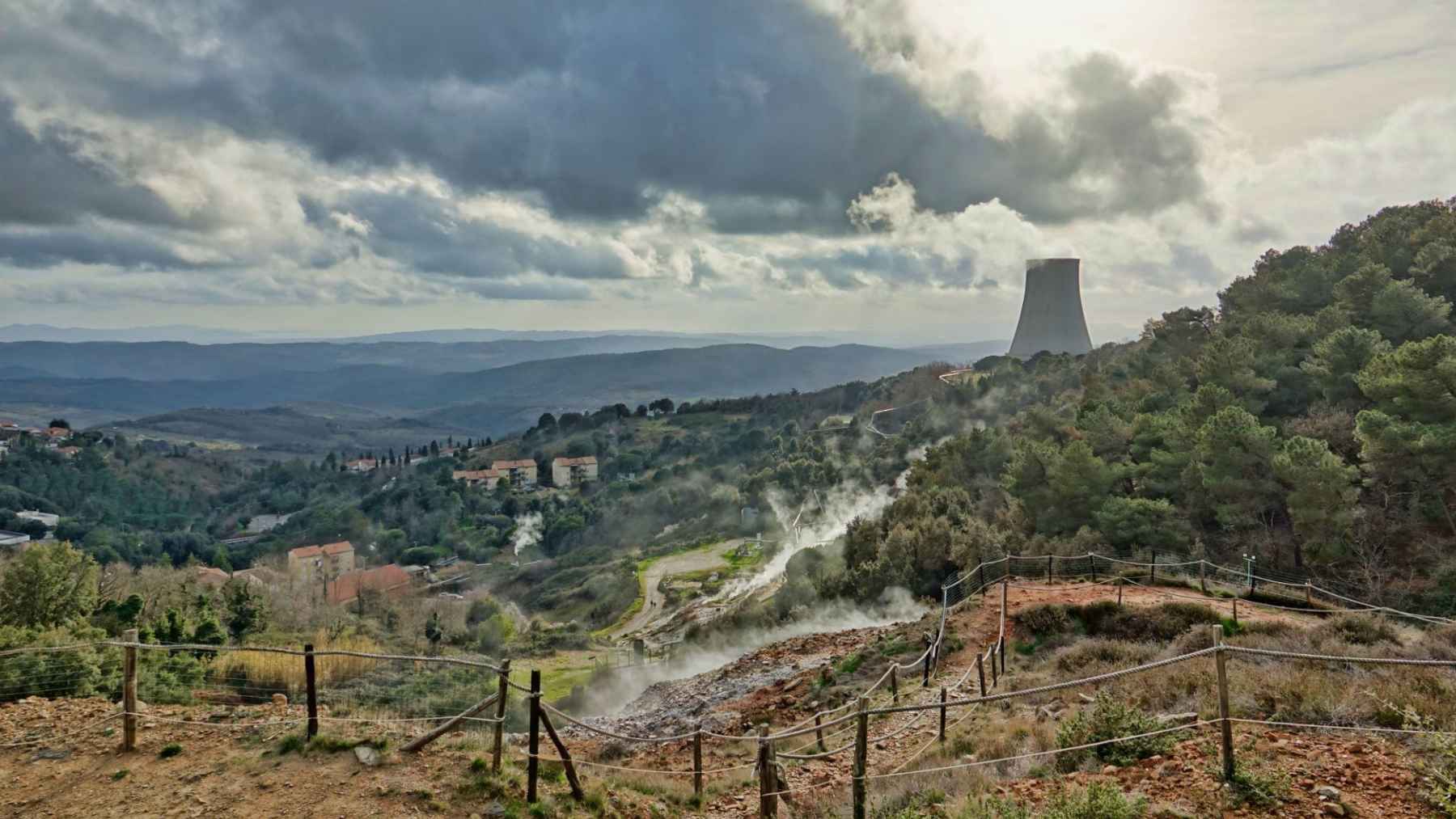 Geothermal steam rising over a rocky landscape, illustrating research on hidden magma beneath Tuscany.