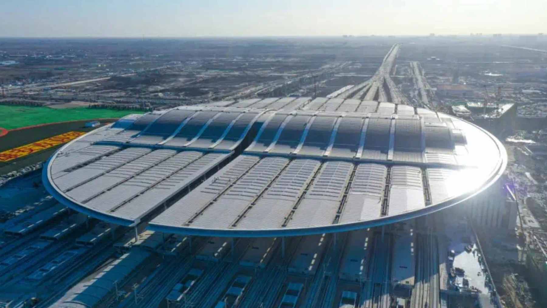 The expansive oval-shaped roof and architectural interior of the massive Xiong’an Railway Station in China.