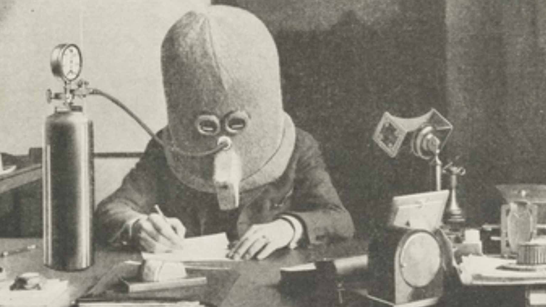A vintage 1925 photograph of a person wearing "The Isolator," a bulky wooden helmet designed to block noise and visual distractions.