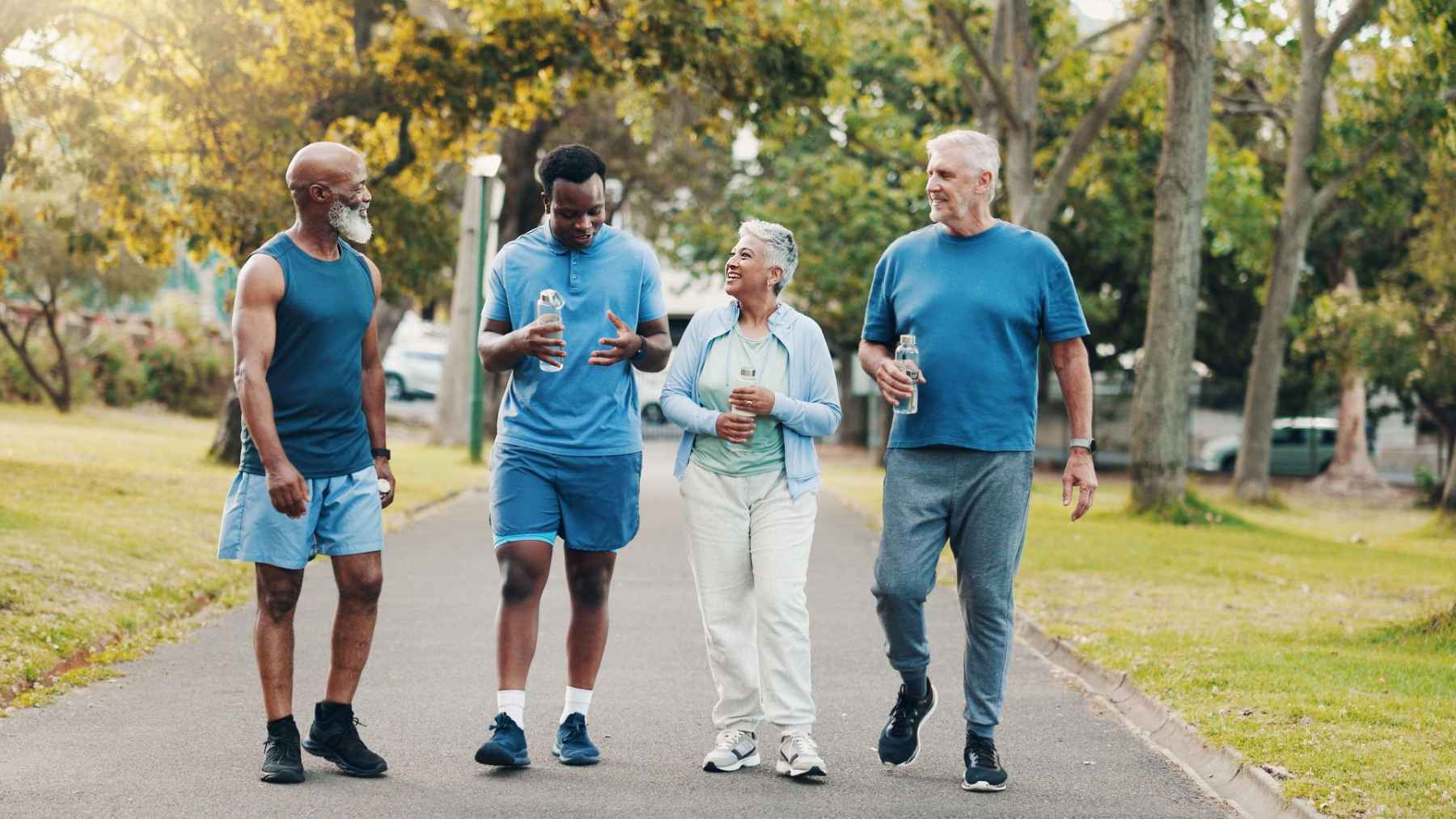People who stay fit as they age treat movement as meaning, not appearance, and that mindset change may be the real longevity advantage 1 Group of adults walking together in a park, reflecting social connection and active lifestyles in aging.