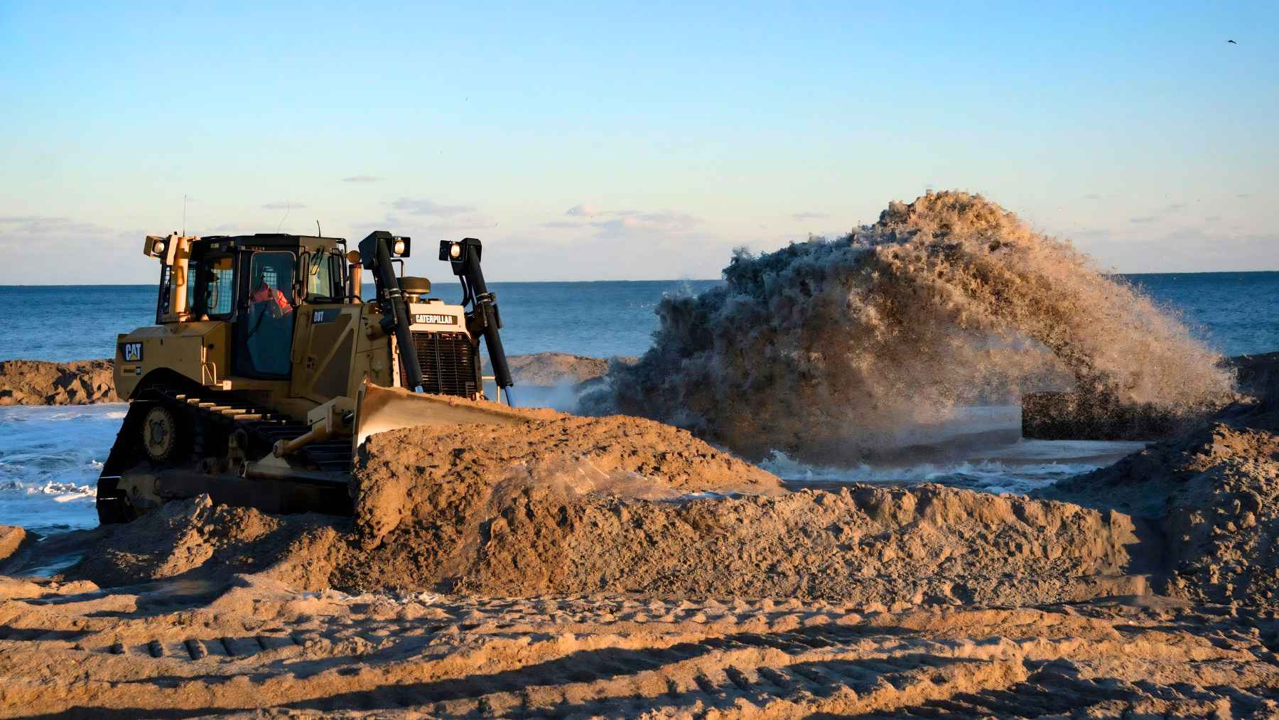 ECOnews 1 Bulldozer pushing sand on a beach as waves crash nearby, illustrating coastal restoration work in Portugal’s Algarve region.