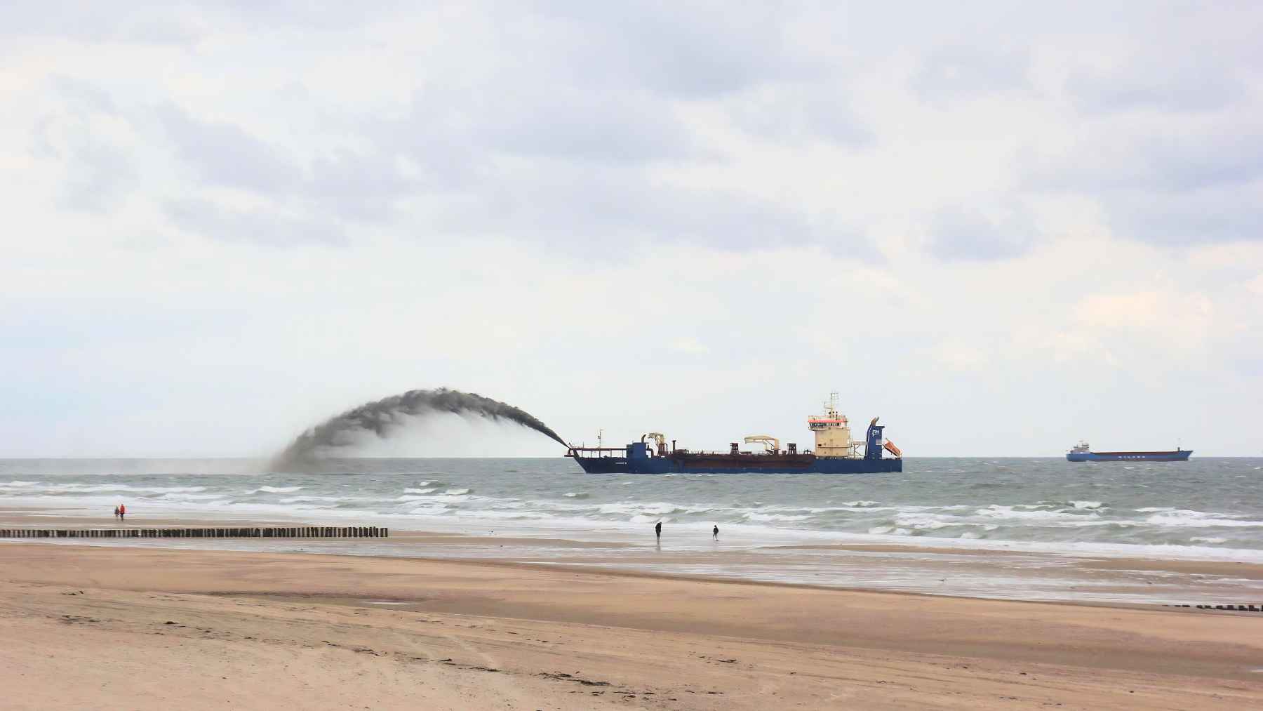Dredging ship pumping sand into the sea near the Algarve coast as part of a beach nourishment project in Portugal.