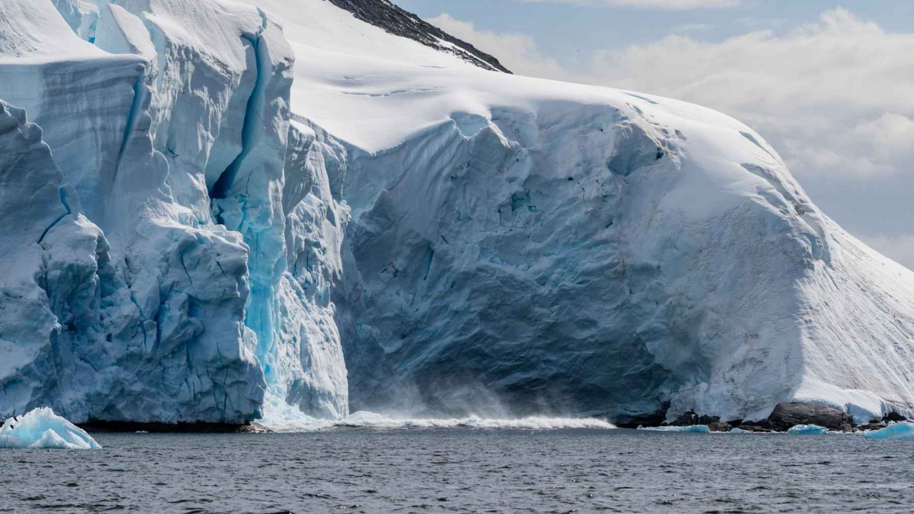 Large Antarctic glacier breaking into the ocean, illustrating ice shelf instability and melting processes.