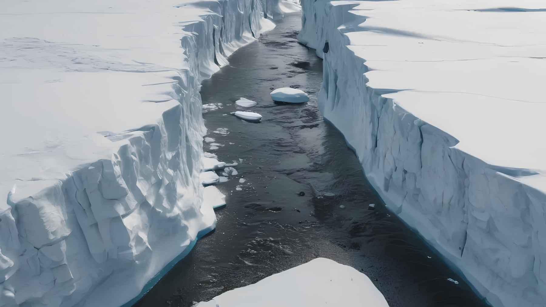 Meltwater channel cutting through Antarctic ice, showing how water flows and weakens ice structures.