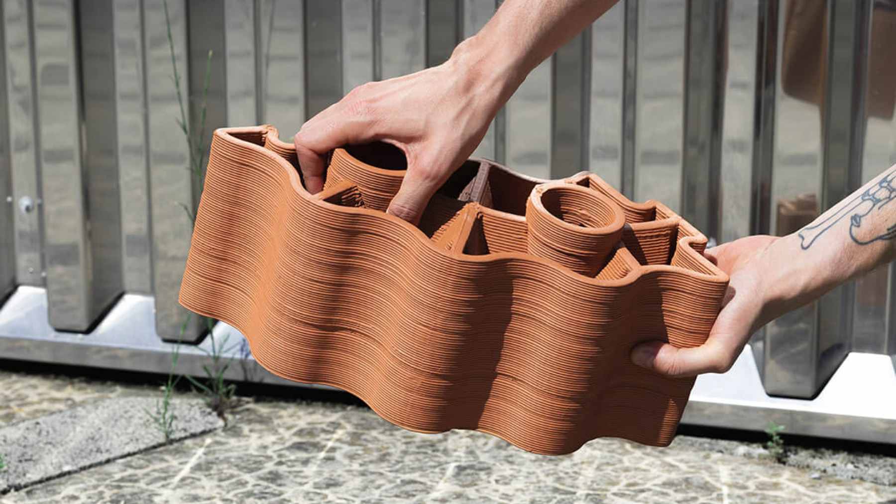 A modular bloc terracotta wall structure designed to cool urban transit stops using water evaporation and solar-powered airflow.