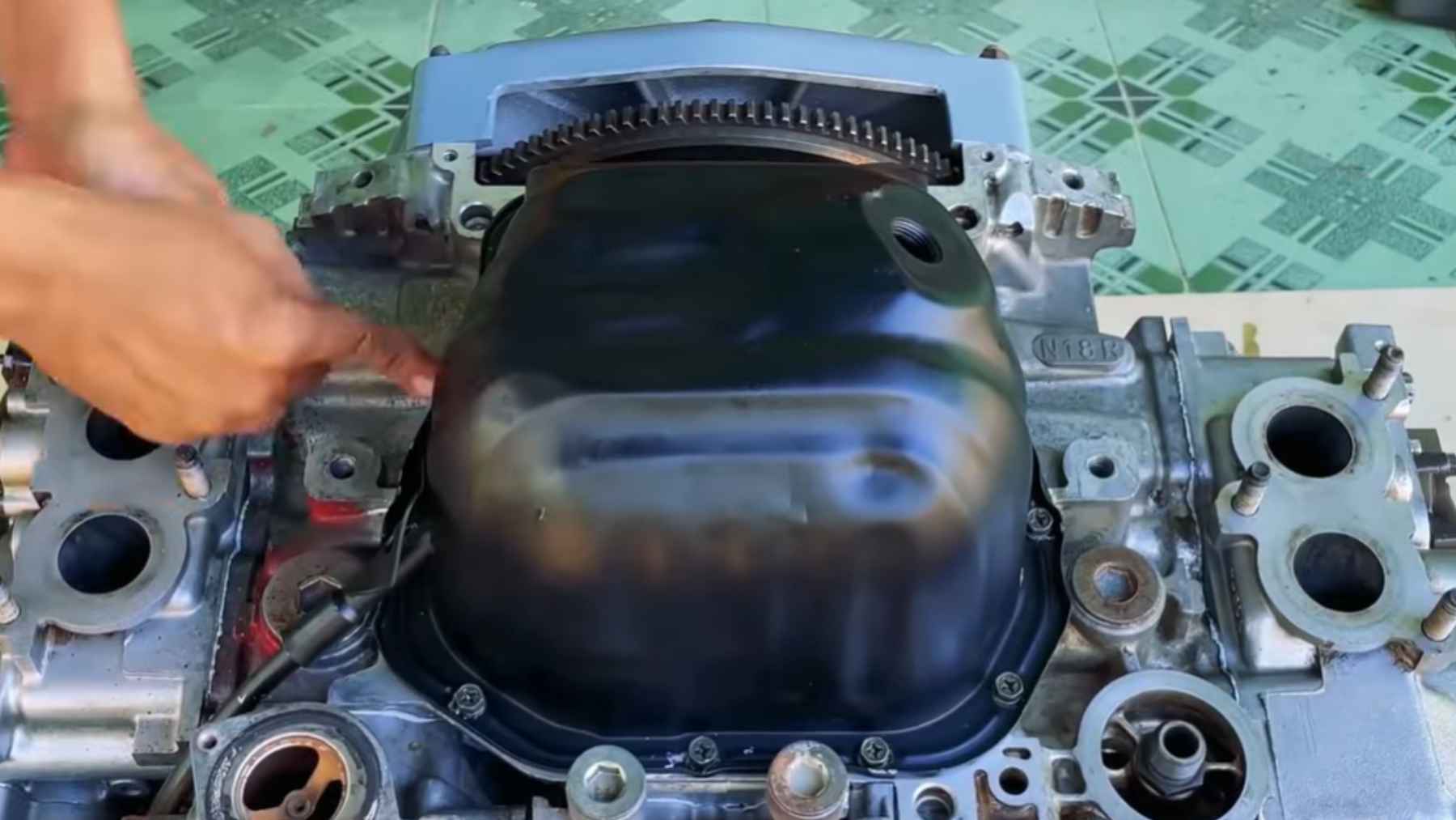 A man turns a car engine into a working boat setup, reroutes cooling with external water, and adds a prop shaft and anticorrosion protection so it actually runs on the water 1 Car engine modified for boat use with custom cooling and sealed housing.