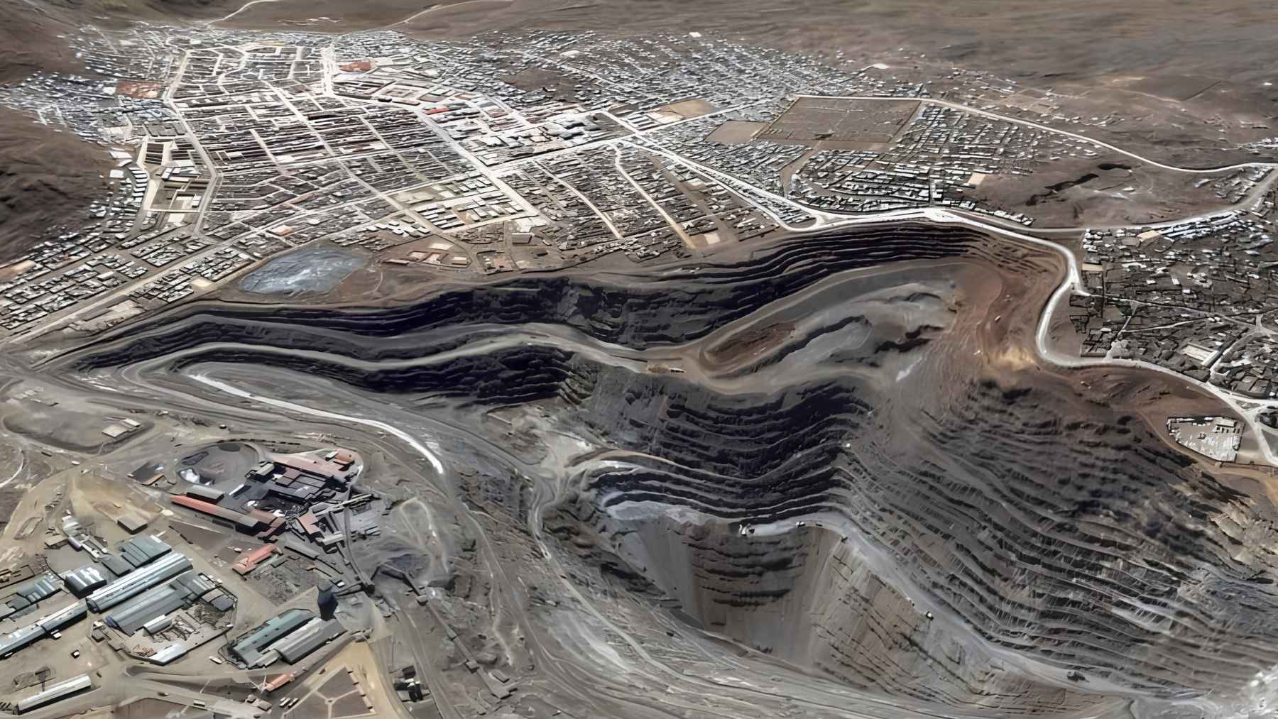 Aerial view of the open-pit mine cutting into Cerro de Pasco beside homes and streets