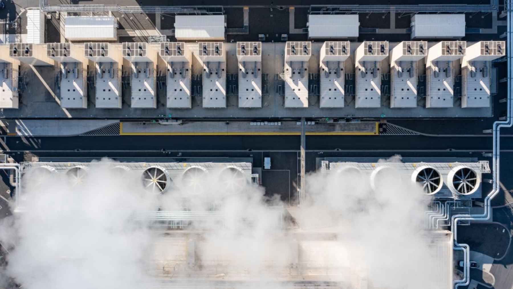 Aerial view of a data center with cooling systems releasing vapor, showing water use for server cooling