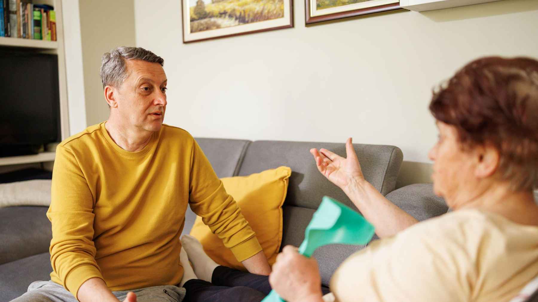 Adult son having a serious emotional conversation with older parent at home