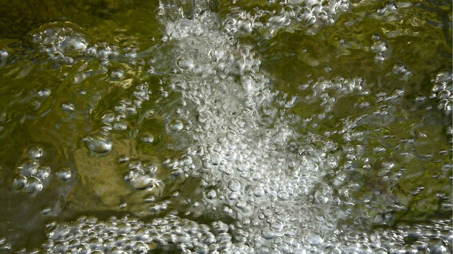 Gas bubbles rising through hot spring water linked to deep mantle helium signals.