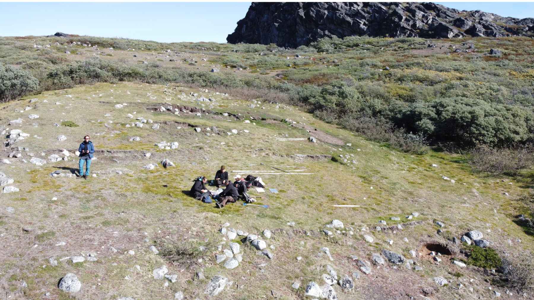 Researchers conducting fieldwork in Greenland for a study on ancient middens preserved by permafrost.