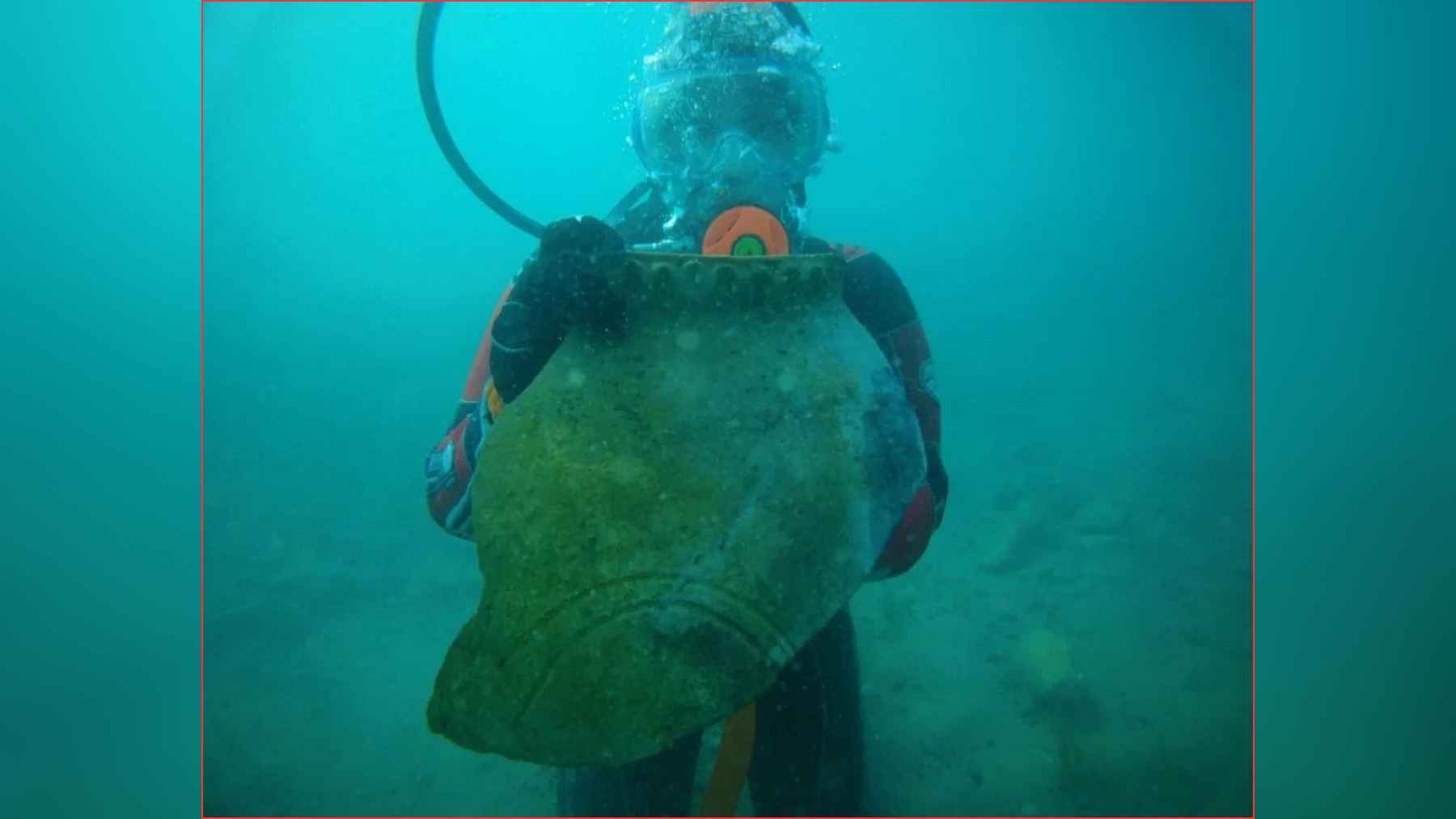 Diver holding a large ceramic vessel recovered from underwater ruins at Lake Issyk-Kul in Kyrgyzstan.