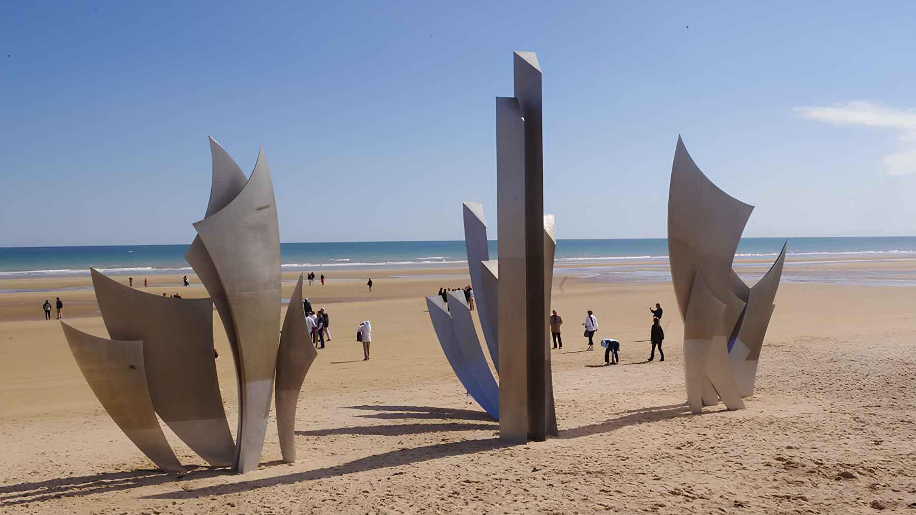 Visitors walk around the Les Braves memorial sculpture on Omaha Beach in Normandy, a key D-Day landing site.