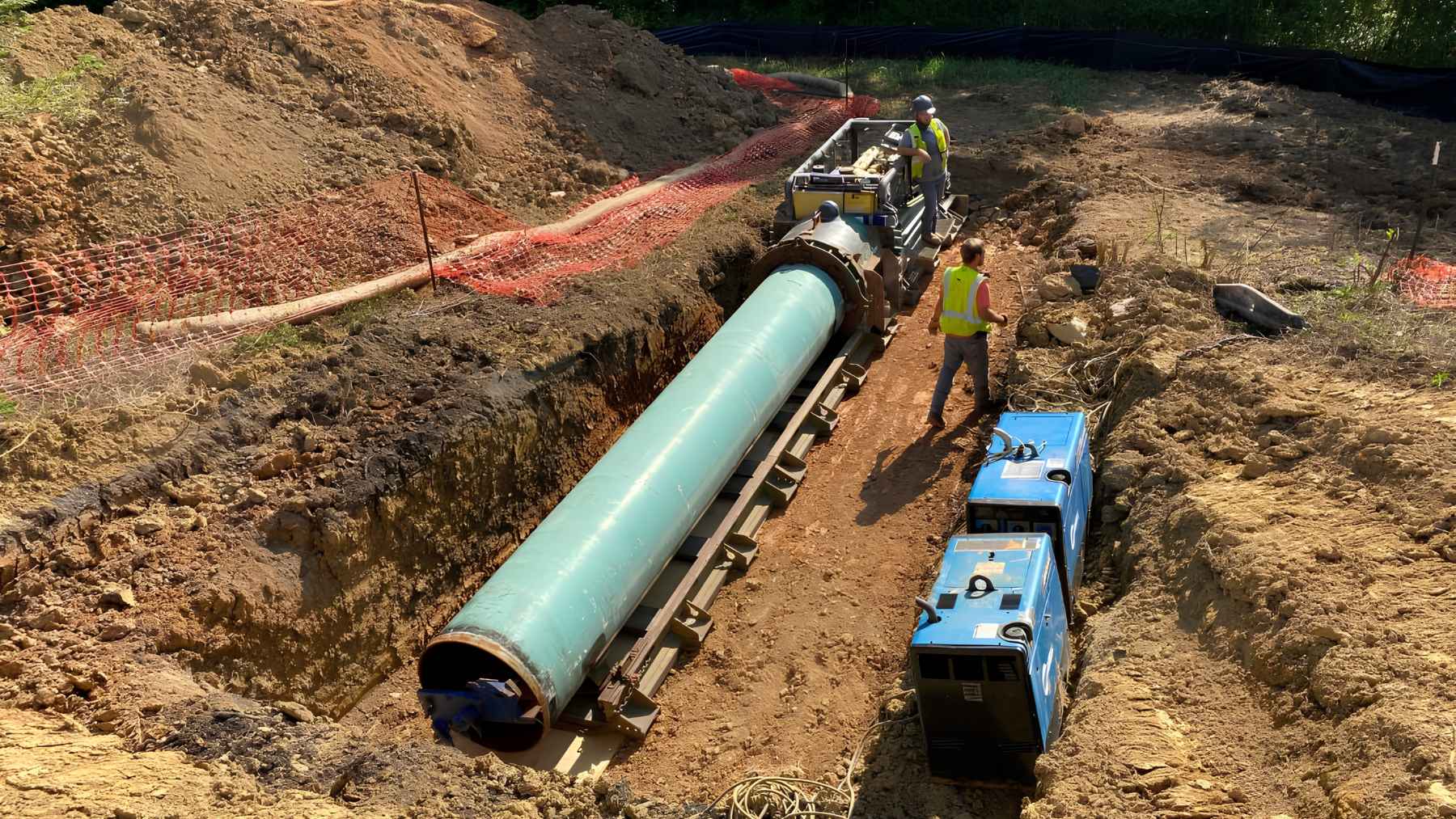 Workers install a steel test tunnel in an excavated trench at Oak Ridge National Laboratory for underground acoustic detection research.