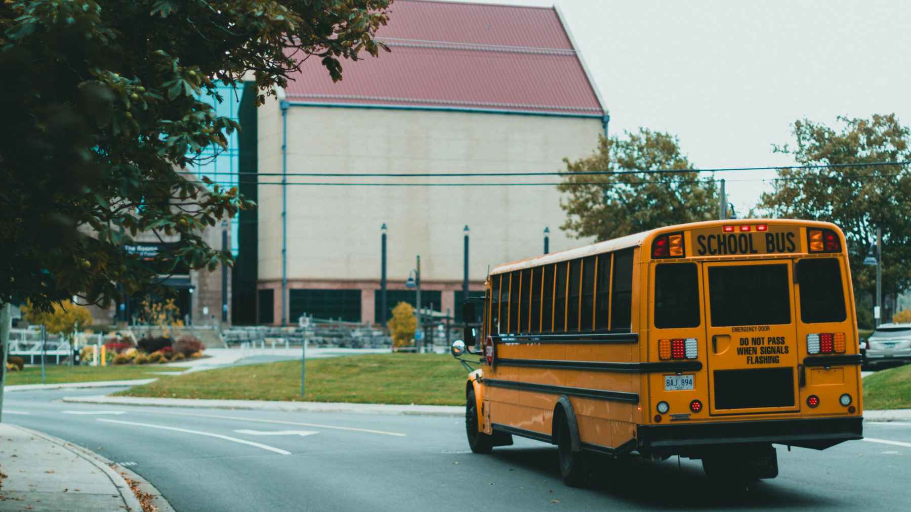 Yellow school bus parked outside a school building, representing U.S. schools where radon gas can accumulate indoors.