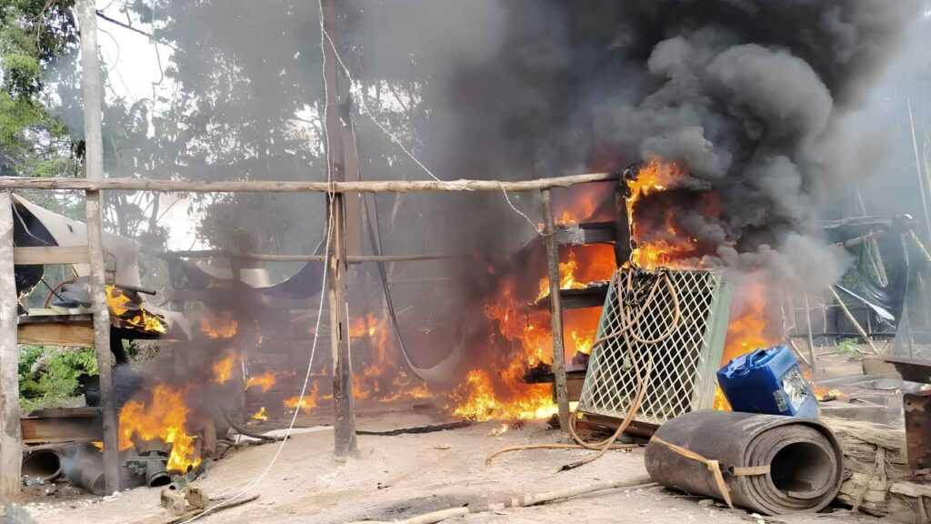 Mining structures burning with heavy smoke during a conflict linked to gold mining activities in Bolivia