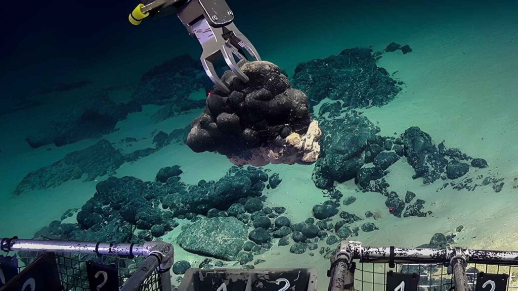 Robotic arm collecting polymetallic nodules from the deep Pacific seafloor during exploration