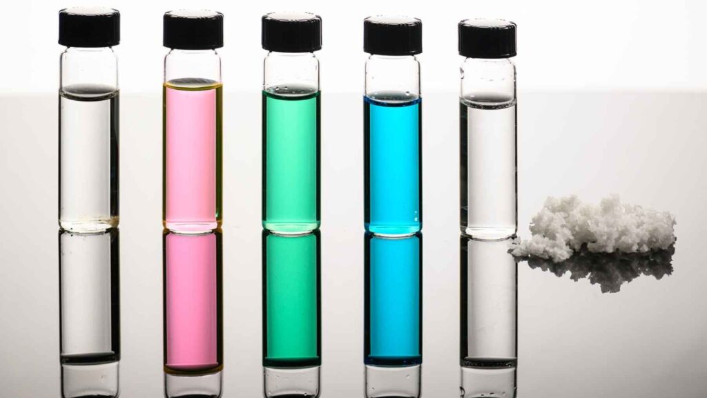 Laboratory vials with different water samples and salt crystals showing stages of desalination and mineral separation