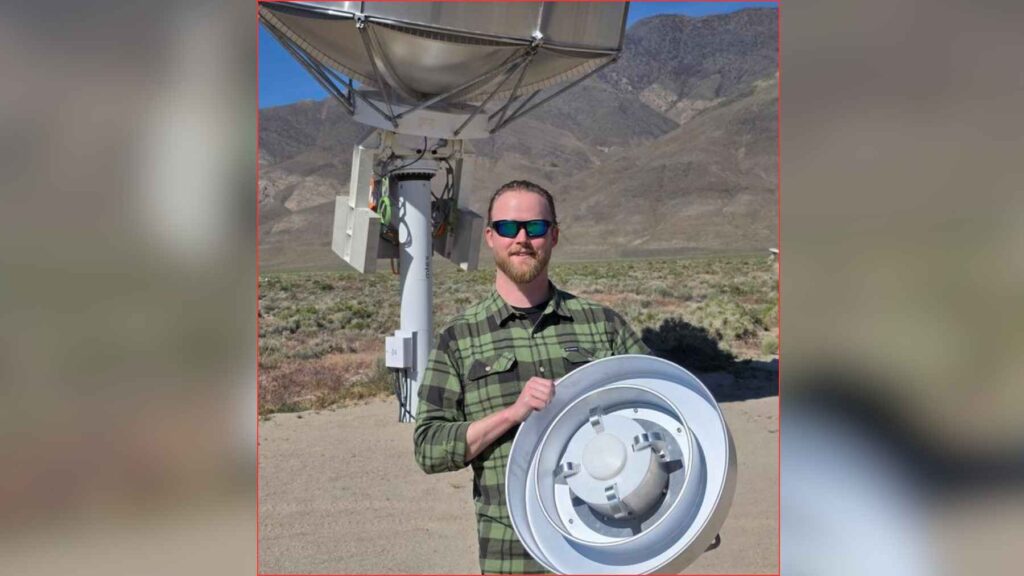 A Caltech researcher holds a radio receiver feed in front of a prototype Deep Synoptic Array antenna at Owens Valley Radio Observatory.