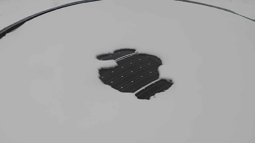 Floating solar panel exposed through ice on a frozen pond during winter experiment