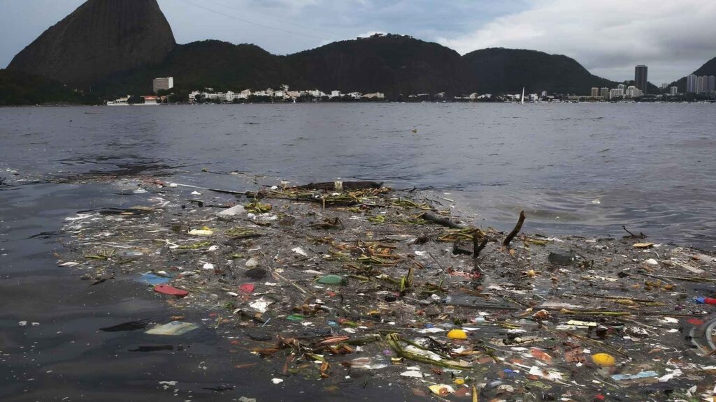 Polluted water in Guanabara Bay filled with floating trash and debris near Rio de Janeiro