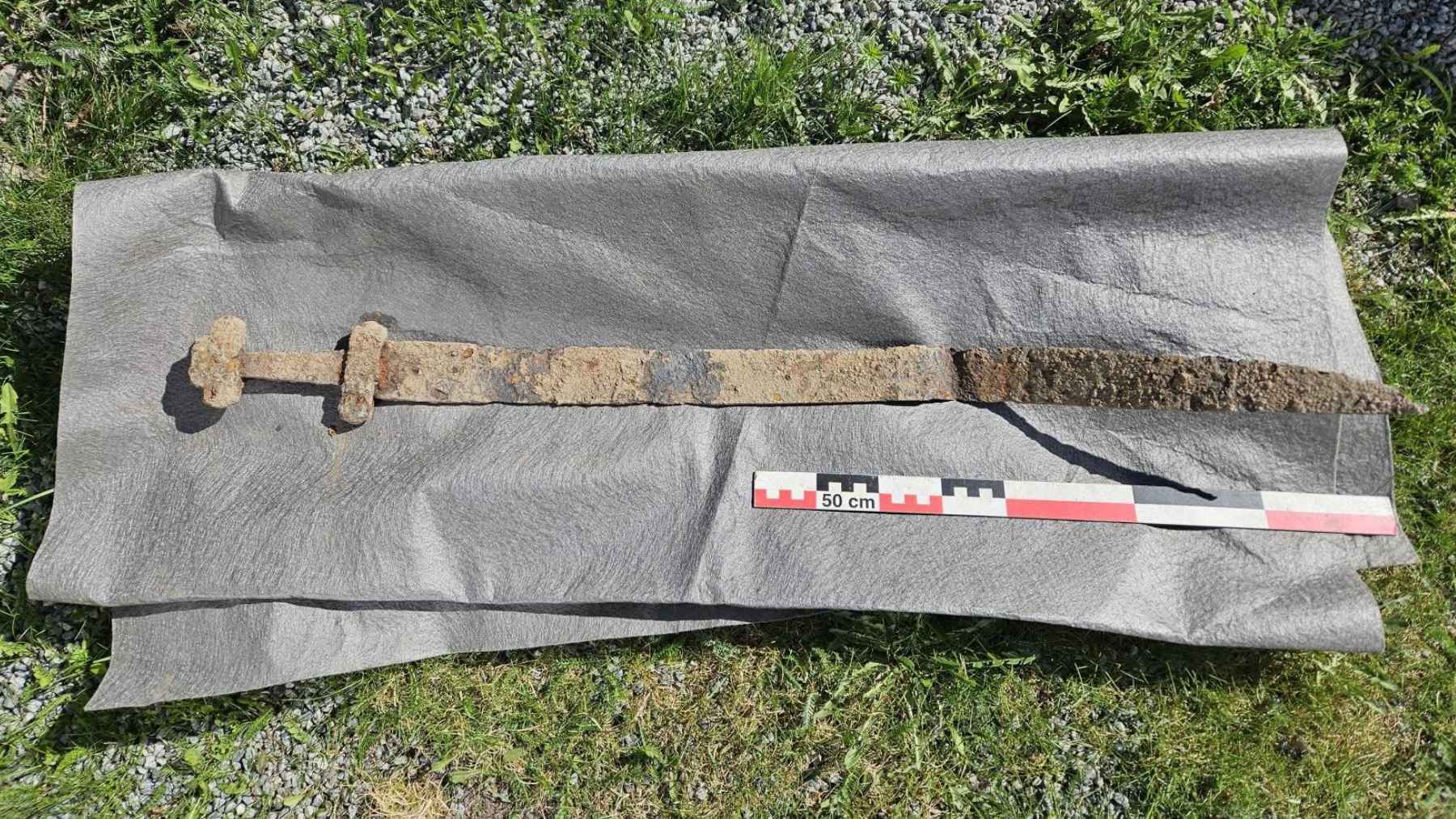 Corroded iron sword laid out after discovery in a field near Brandbu, Norway, where a 6-year-old found the early Viking Age weapon.