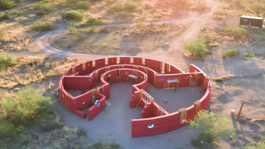 Round off grid desert home made of earth walls under construction in a dry landscape
