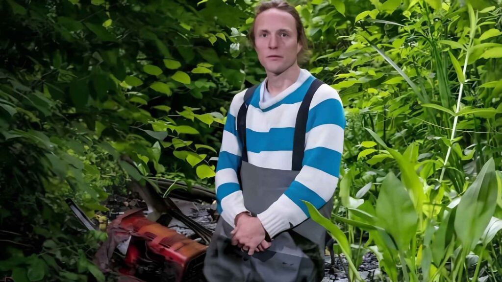 Environmental lawyer Paul Powlesland standing near a polluted urban river in London.