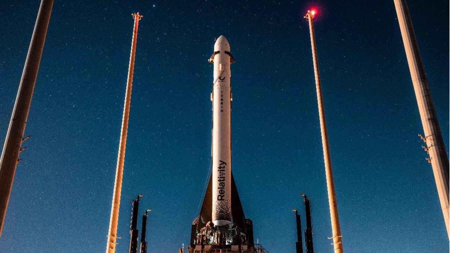 Relativity Space rocket standing on a launch pad at night, linked to NASA’s 2028 Aeolus mission to study Martian weather.