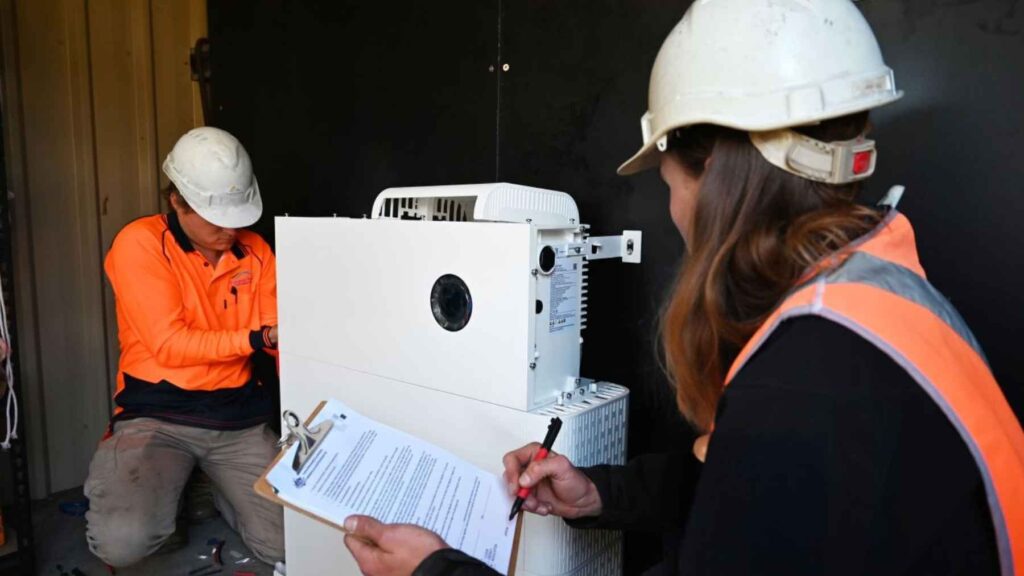 Technicians install a residential battery system designed for virtual power plant participation.