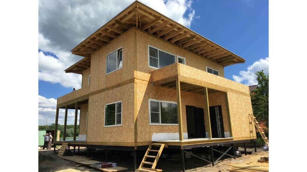 A two-story home under construction using structural insulated panels (SIPs), showcasing a prefabricated building system designed for faster, energy-efficient construction.