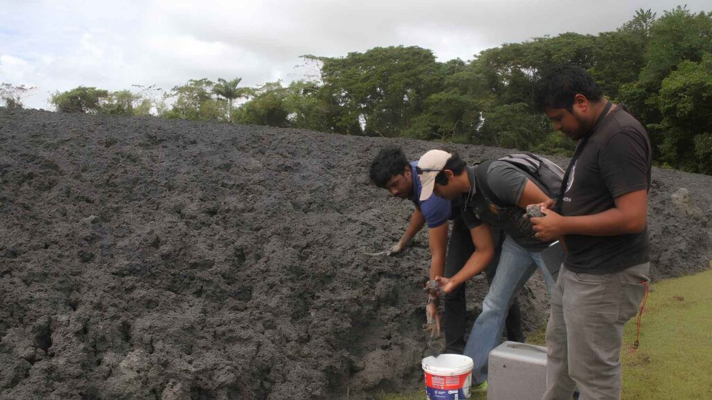 Scientists collect samples from a mud volcano in Trinidad to study its geology and activity.