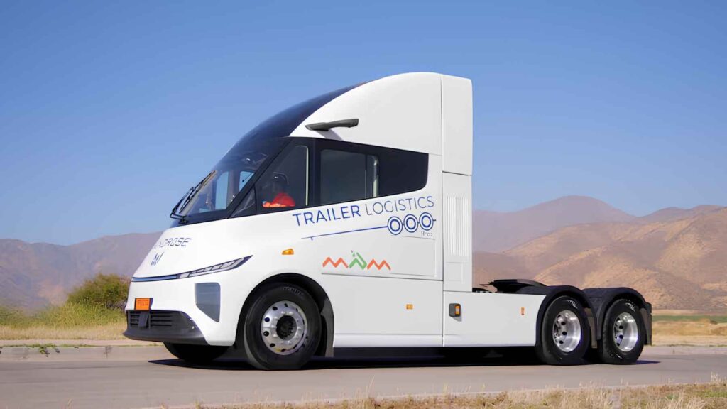 Side view of a Windrose electric tractor from Trailer Logistics driving past mountains on a clear Chilean highway.