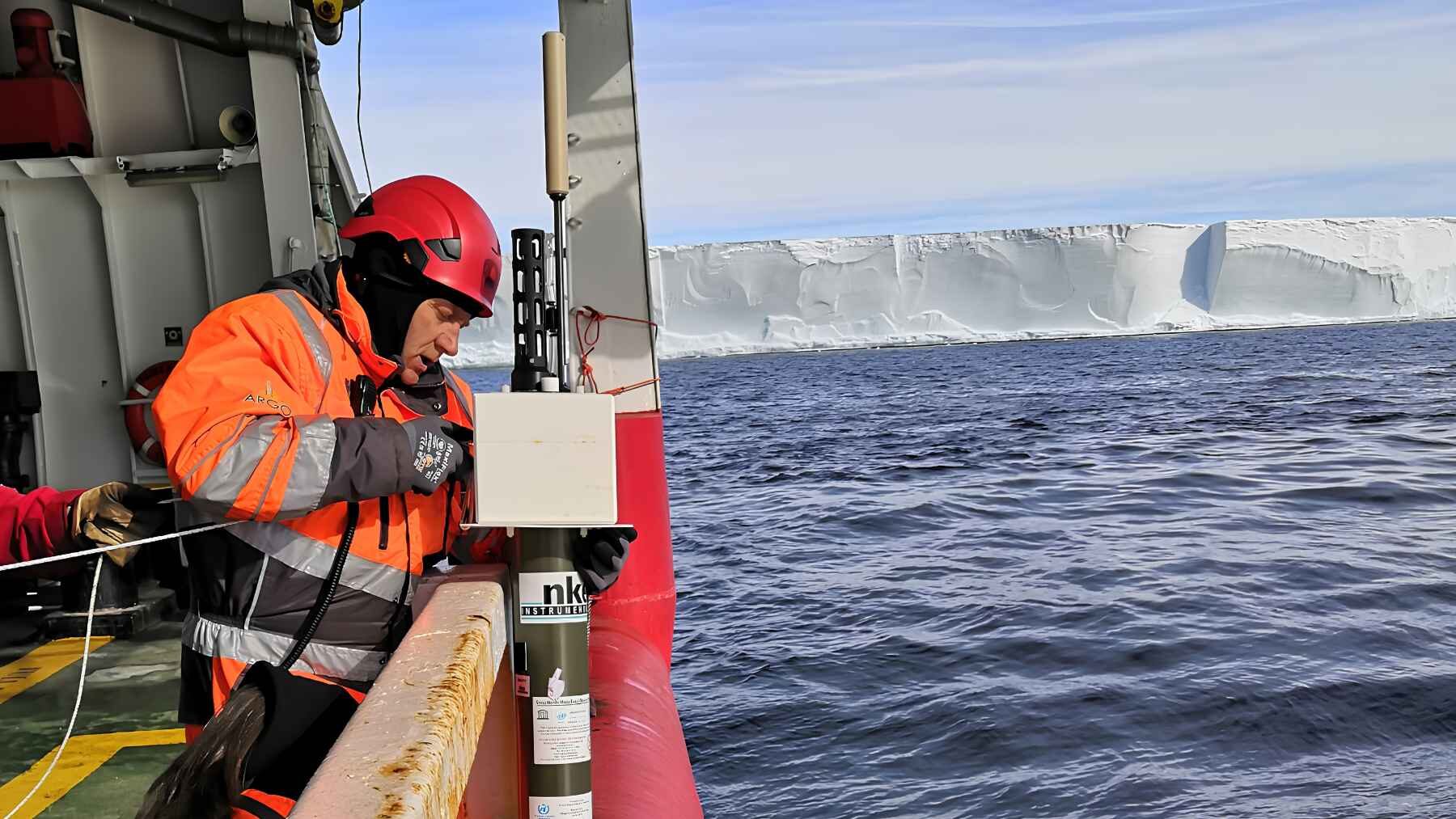 Scientist deploying an oceanographic instrument near Antarctica to monitor deep ocean temperature and salinity.