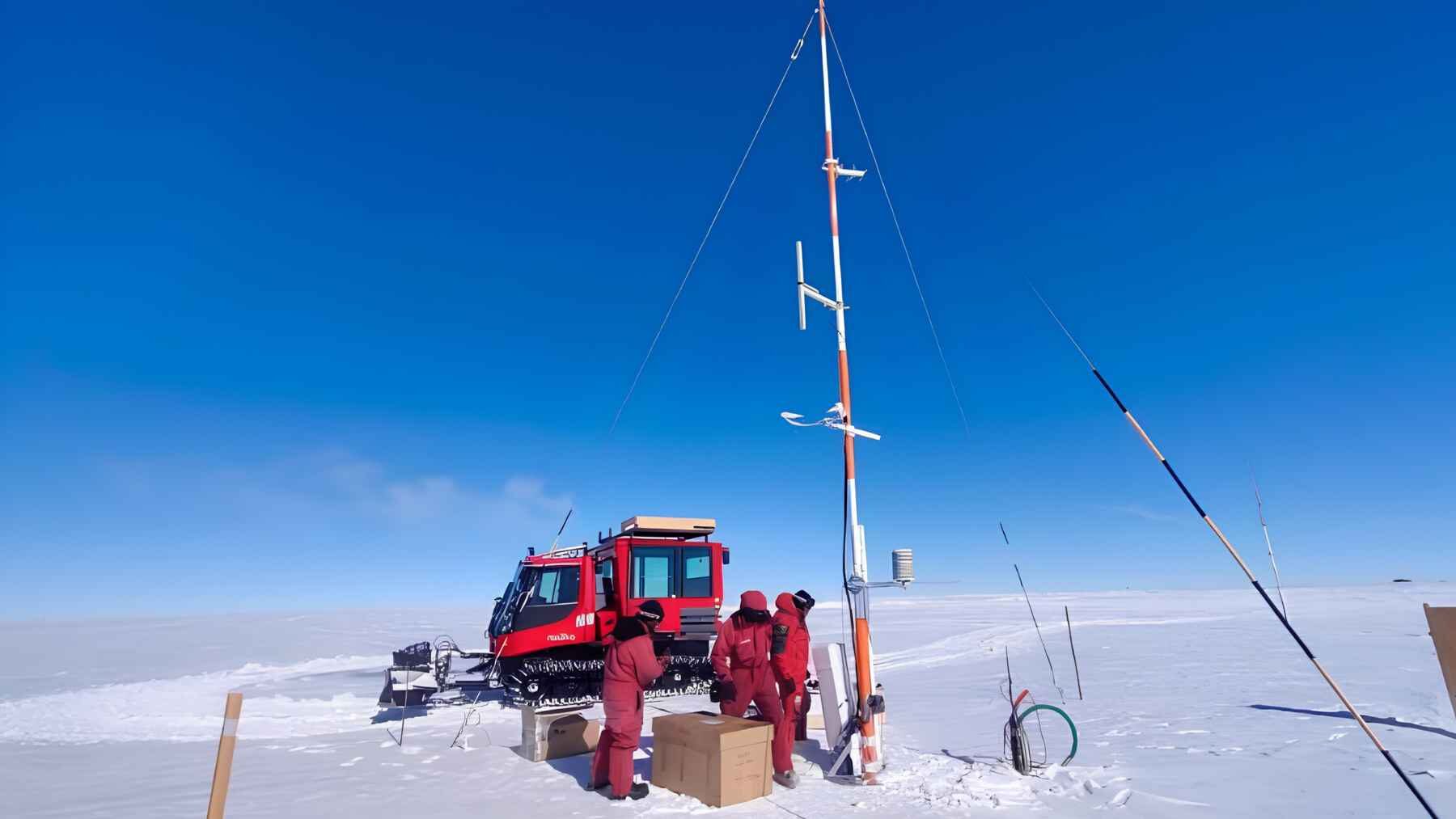 Researchers working beside weather instruments near Concordia Research Station in Antarctica.