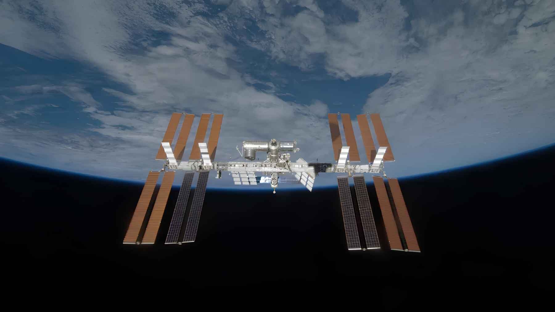 International Space Station orbiting above Earth with its solar arrays fully visible.