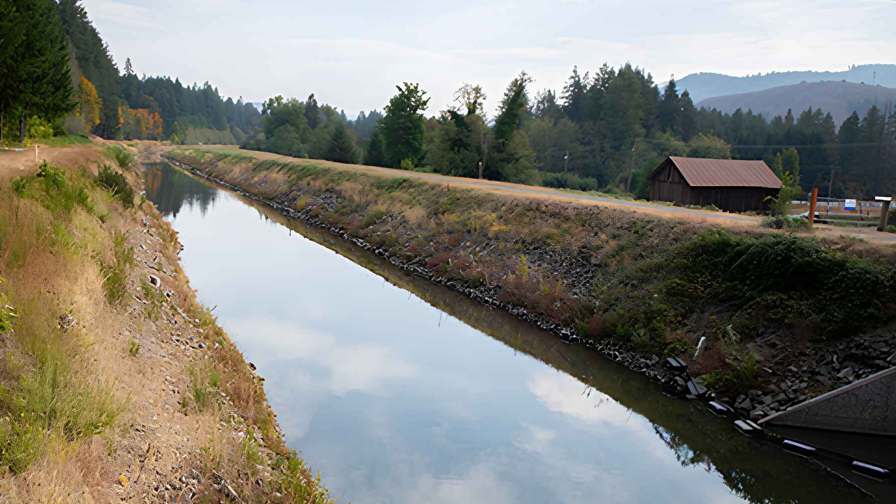 Leaburg Canal runs between earthen embankments near the McKenzie River in Oregon.