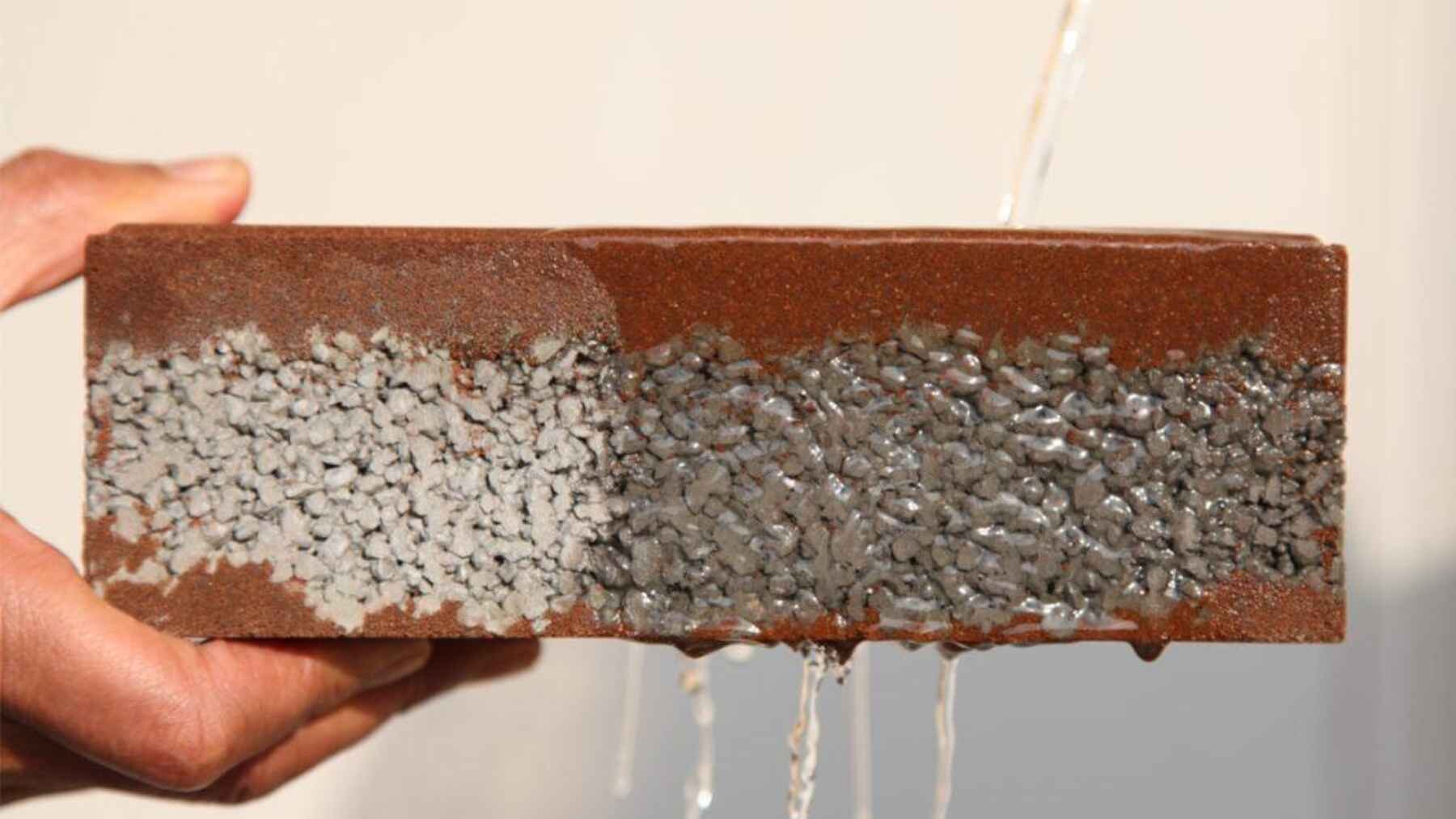 Cross-section of permeable pavement showing how water passes through connected pores into the stone base below.
