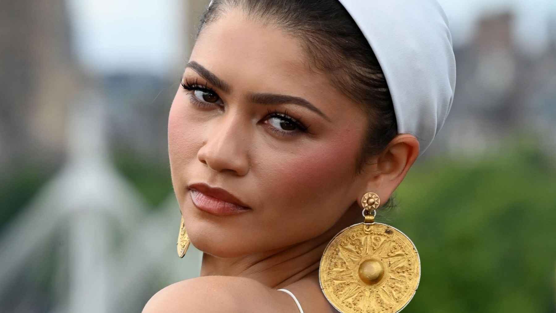 Zendaya wearing earrings incorporating ancient Iranian gold plaques at The Odyssey photocall in London.