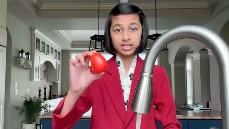 Arika Kundu holding produce while demonstrating her LIGNEX food-safety project.