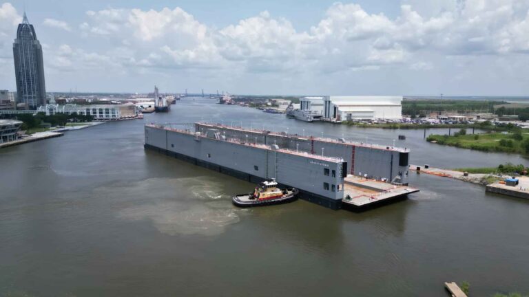U.S. Navy AFDM 15 floating dry dock being maneuvered on the Mobile River in Alabama.