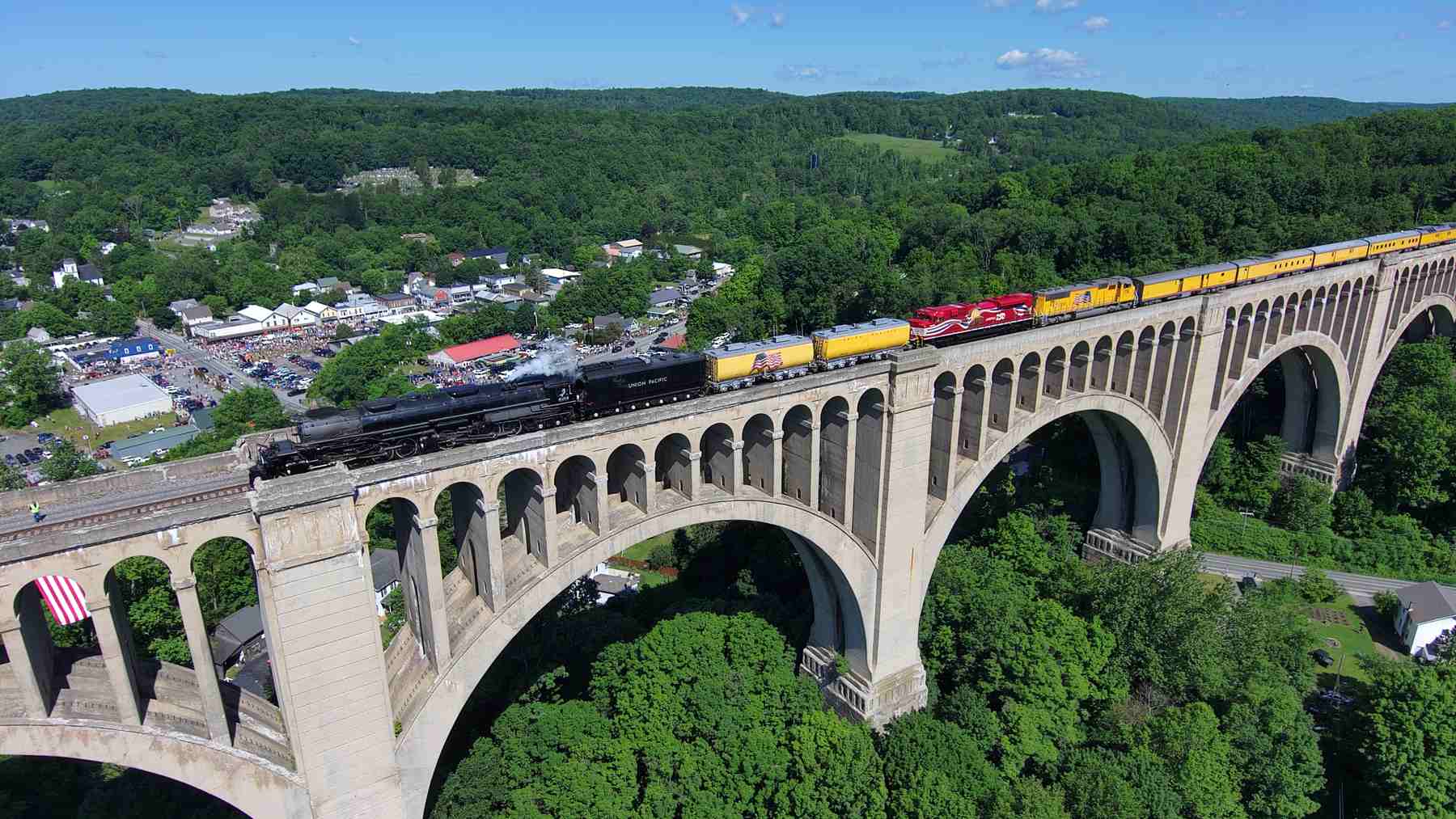 Big Boy No. 4014 crosses the Tunkhannock Creek Viaduct in Pennsylvania with two diesel locomotives coupled behind it.
