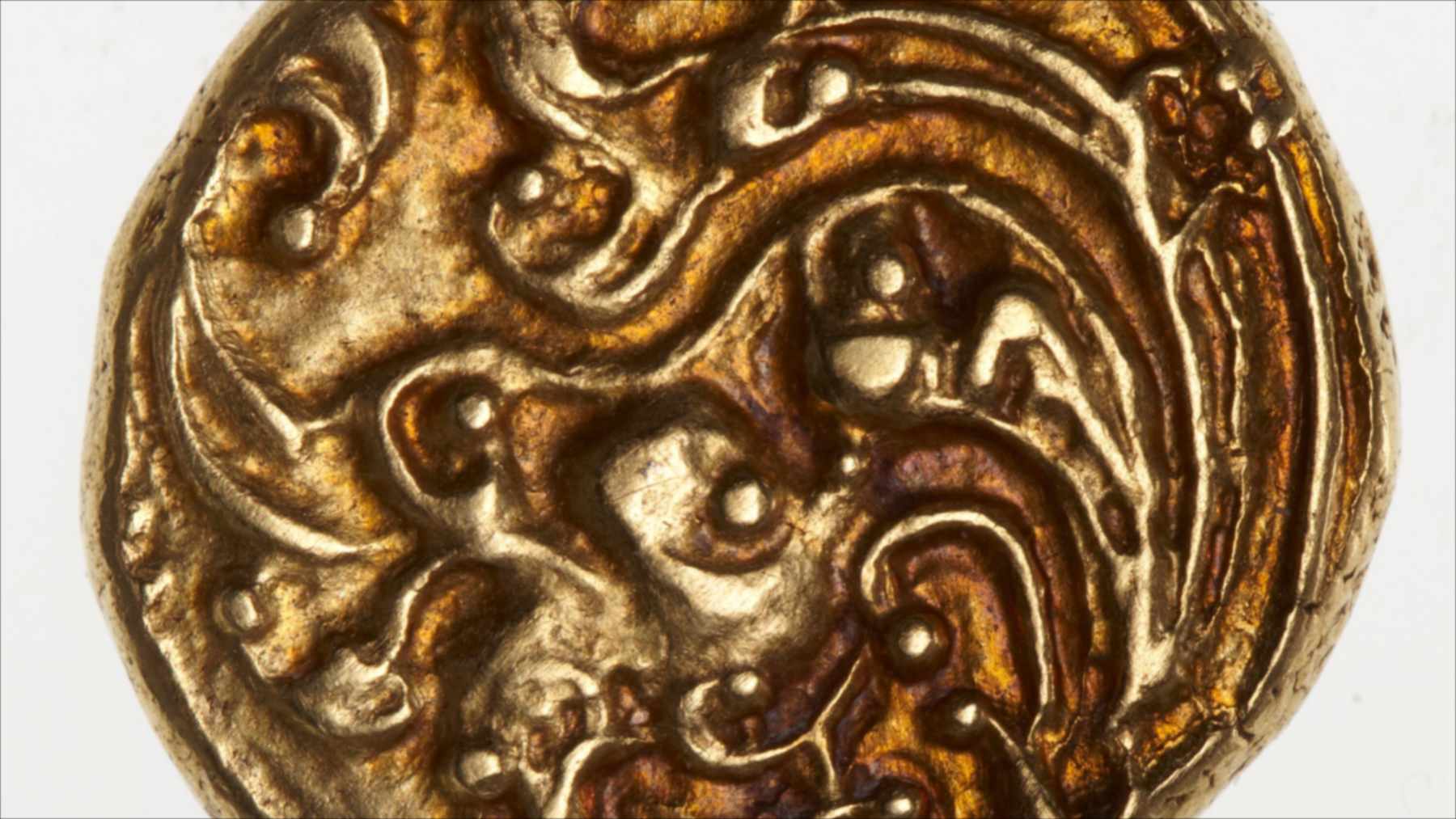 Close-up of a gold pagoda coin from southern India showing a worn raised design