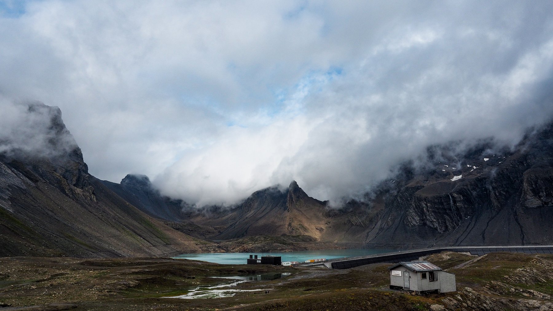 Alpine Muttsee reservoir surrounded by rocky mountains in summer