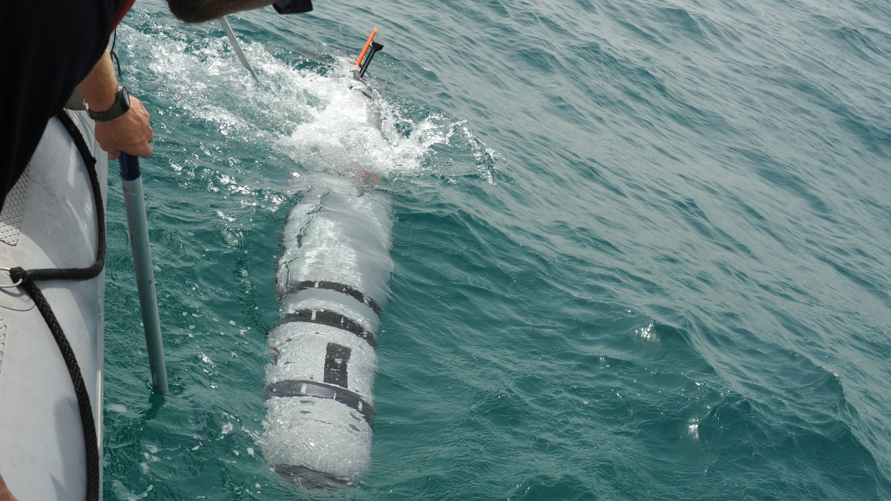 U.S. Navy sailors deploying an unmanned underwater vehicle at sea