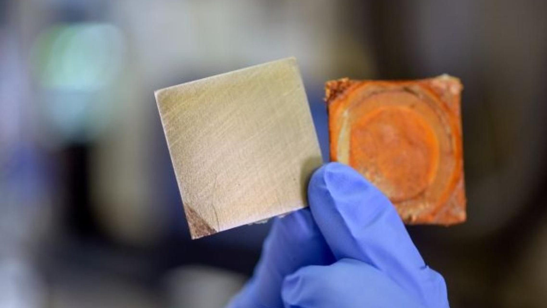 Coated steel samples held by a researcher