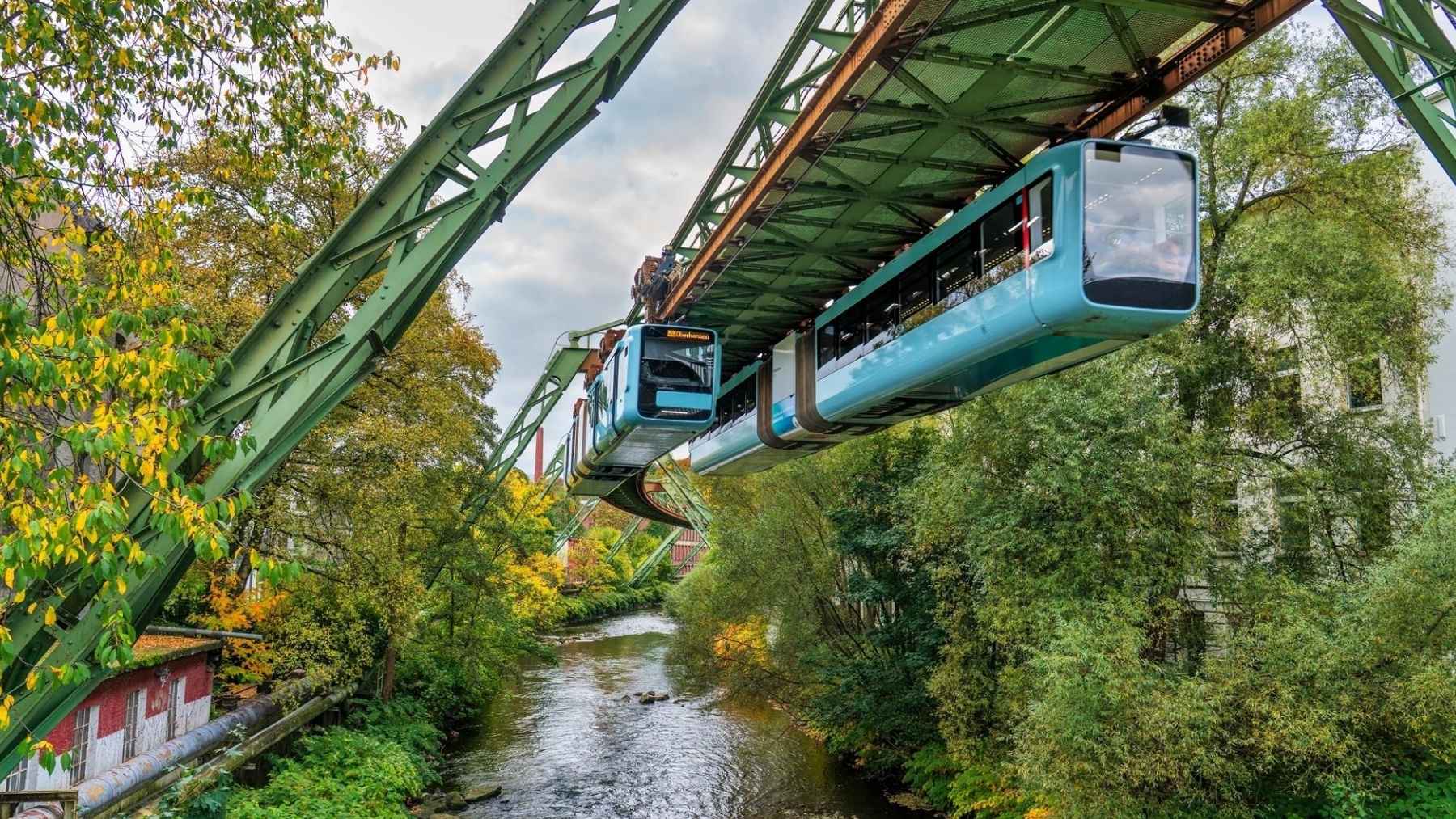Blue Wuppertal Schwebebahn trains suspended above the Wupper River in Germany