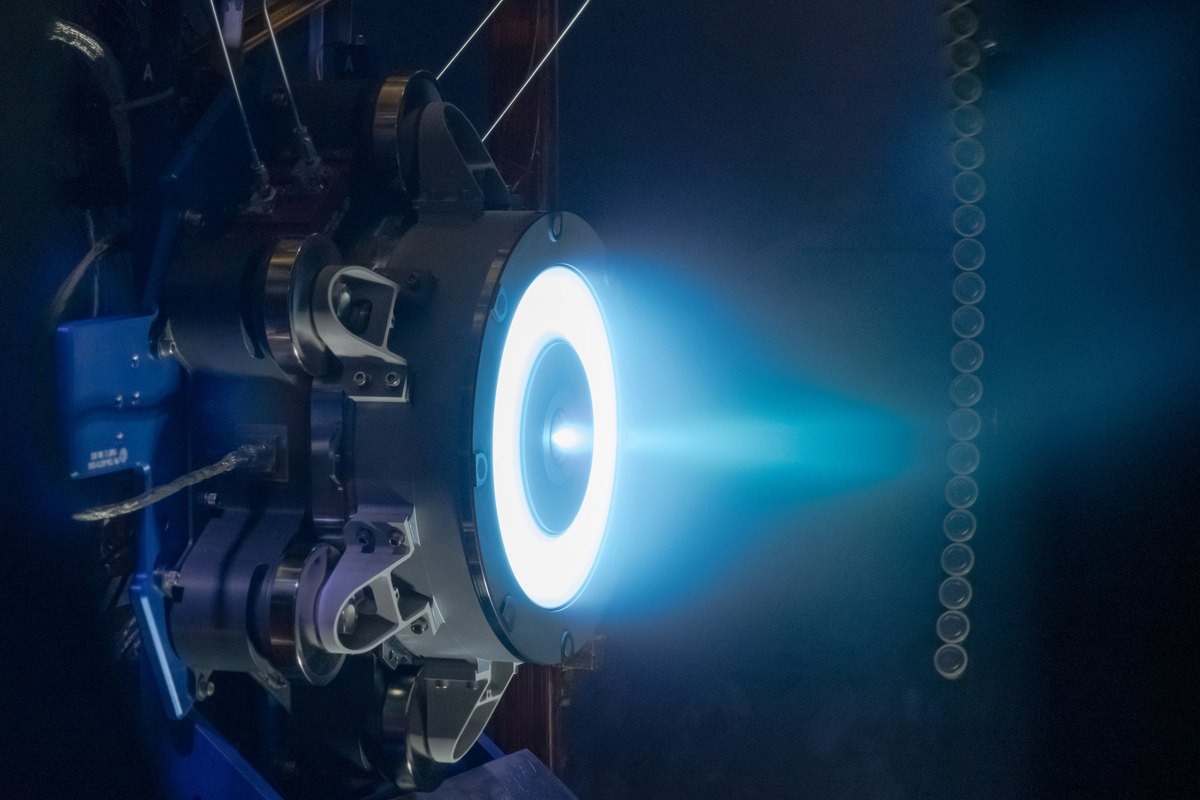 Advanced Electric Propulsion System Hall thruster firing a blue plume inside a vacuum chamber at NASA Glenn
